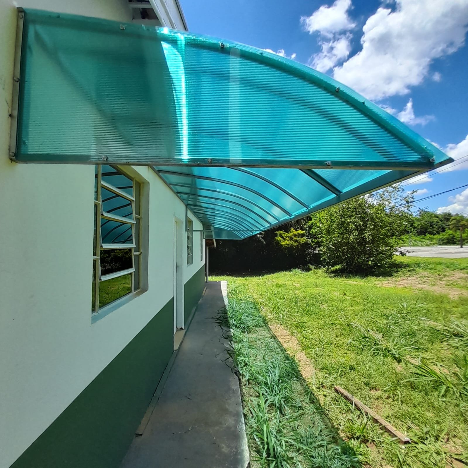 Imagem de toldos e coberturas instalados para proteção solar e conforto em áreas externas.
