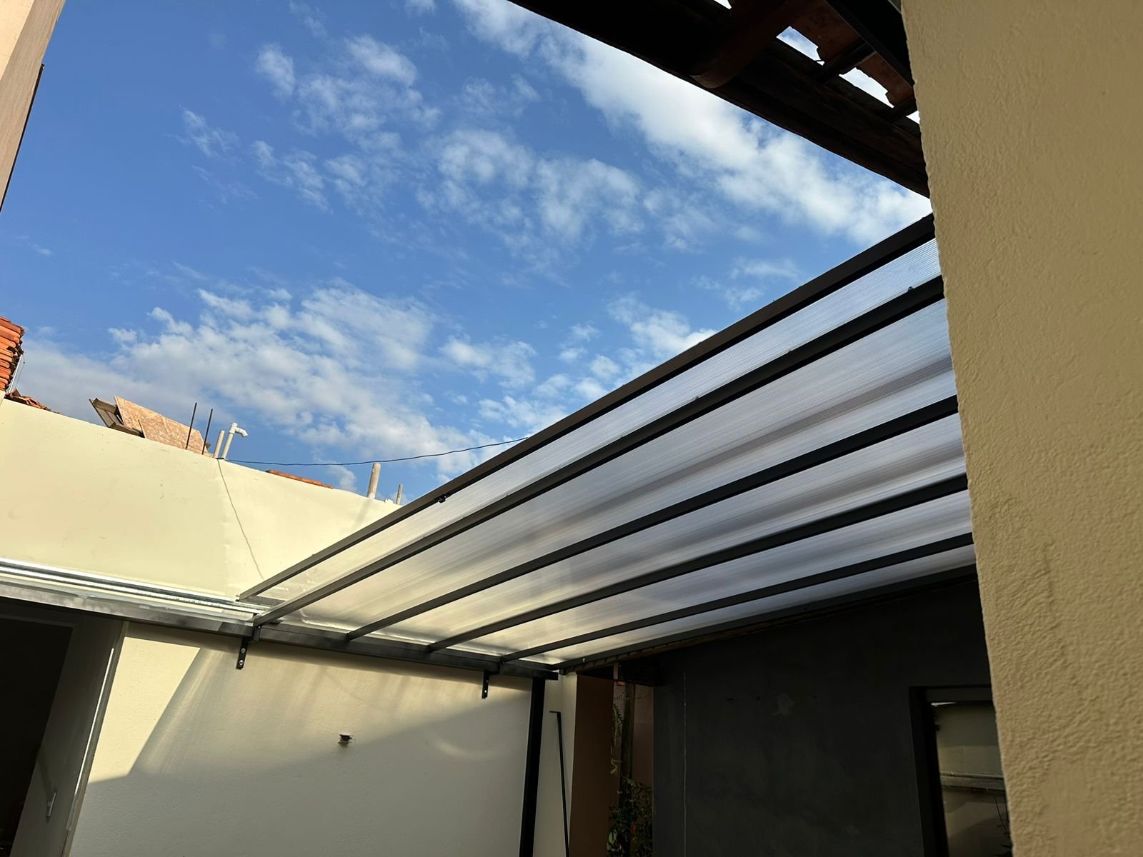 Imagem de toldos e coberturas instalados para proteção solar e conforto em áreas externas.