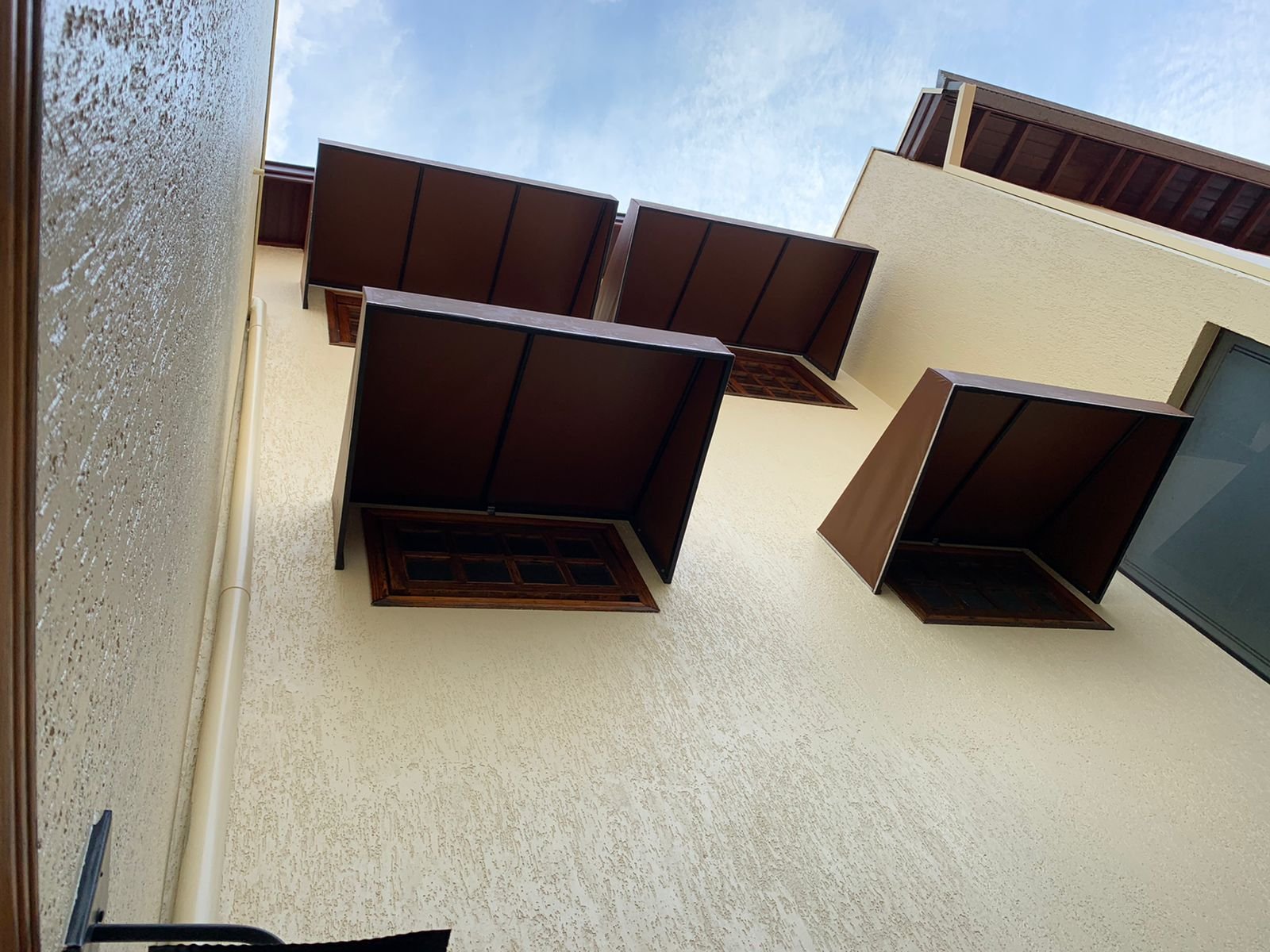 Imagem de toldos e coberturas instalados para proteção solar e conforto em áreas externas.