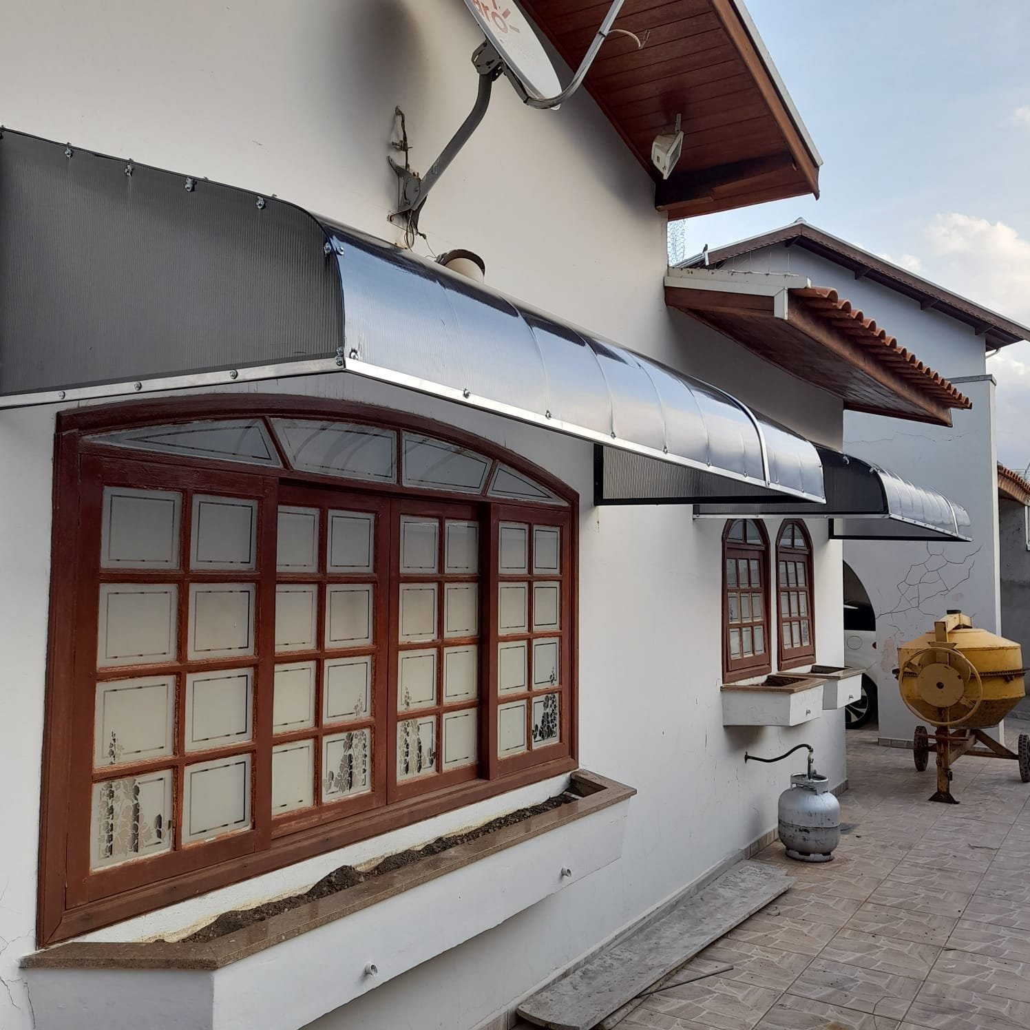Imagem de toldos e coberturas instalados para proteção solar e conforto em áreas externas.