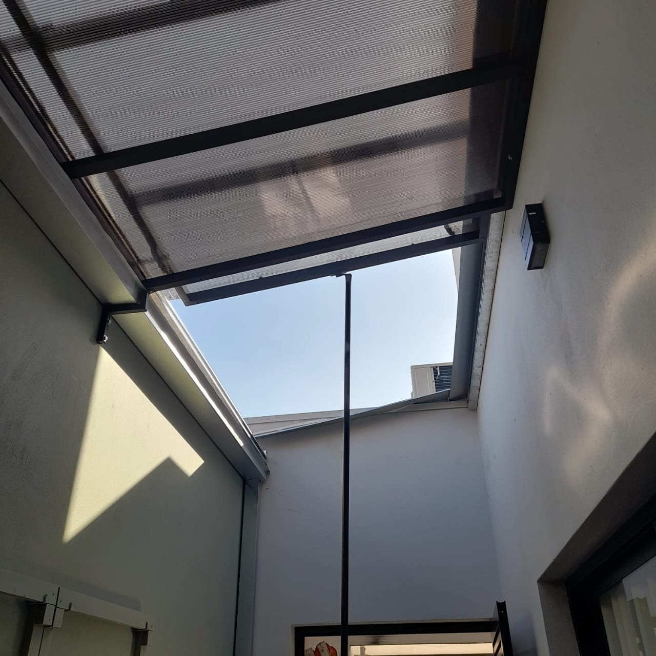 Imagem de toldos e coberturas instalados para proteção solar e conforto em áreas externas.