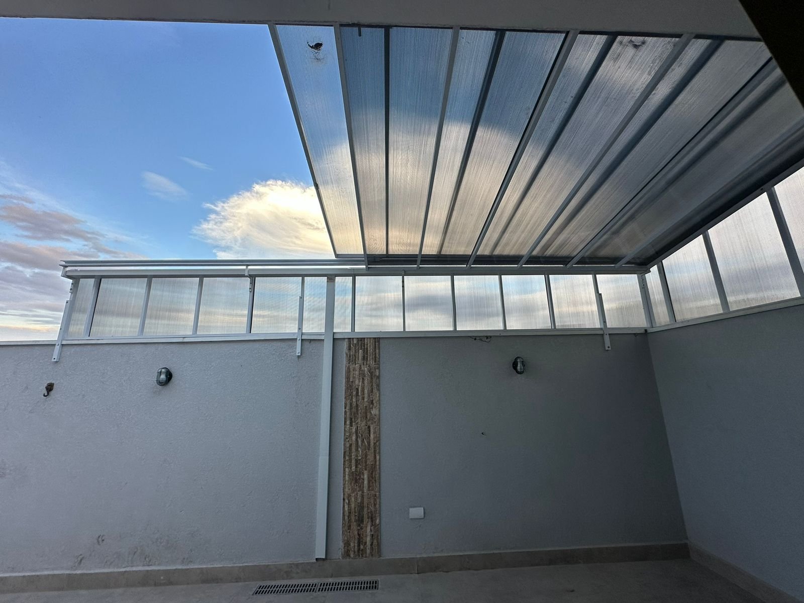Imagem de toldos e coberturas instalados para proteção solar e conforto em áreas externas.