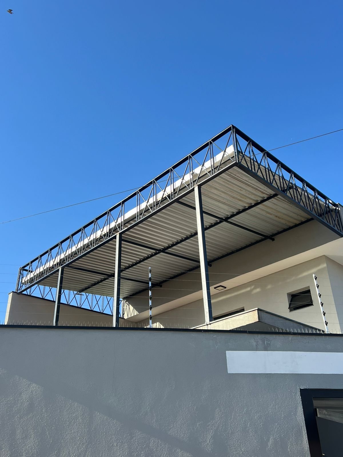 Imagem de toldos e coberturas instalados para proteção solar e conforto em áreas externas.