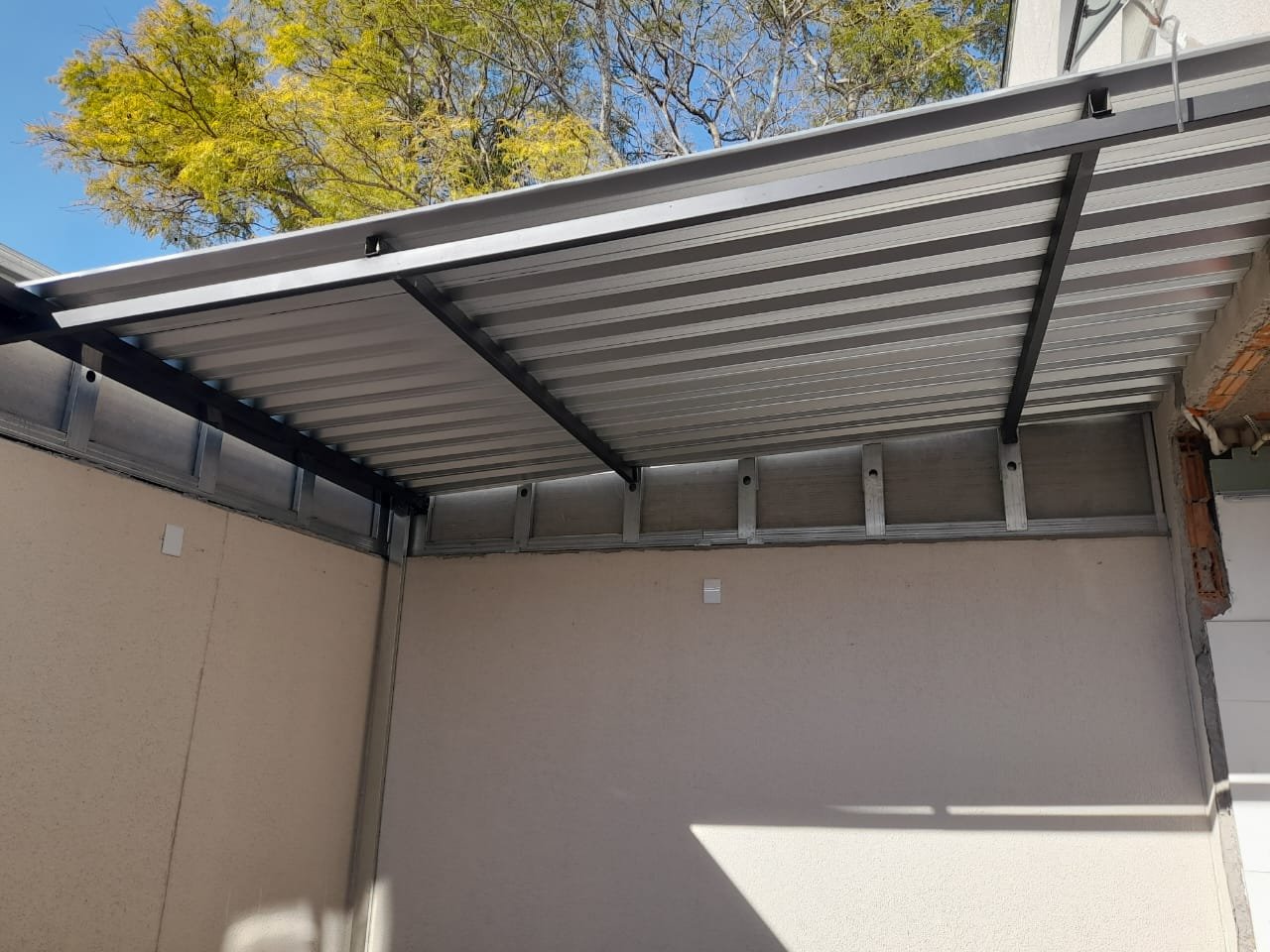 Imagem de toldos e coberturas instalados para proteção solar e conforto em áreas externas.