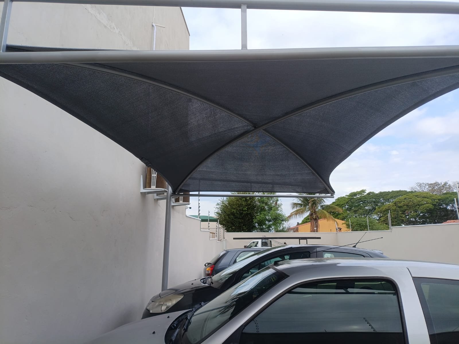 Imagem de toldos e coberturas instalados para proteção solar e conforto em áreas externas.